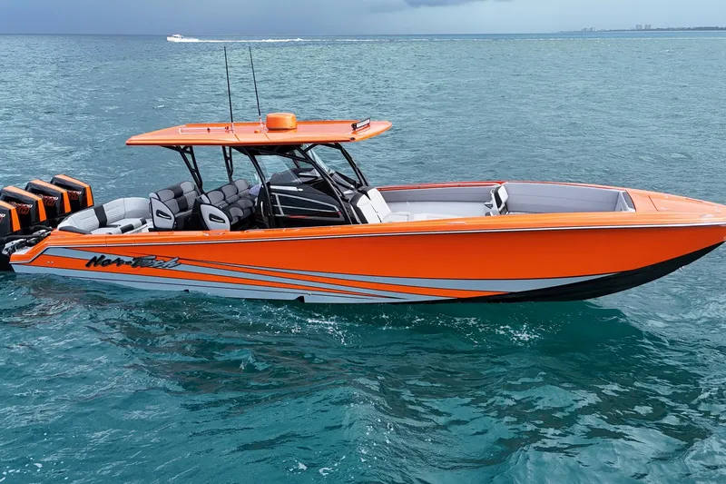 Slide: The Image of 2026 Nor-Tech 390 Sport Center Console boat in vibrant orange on open water. - 0
