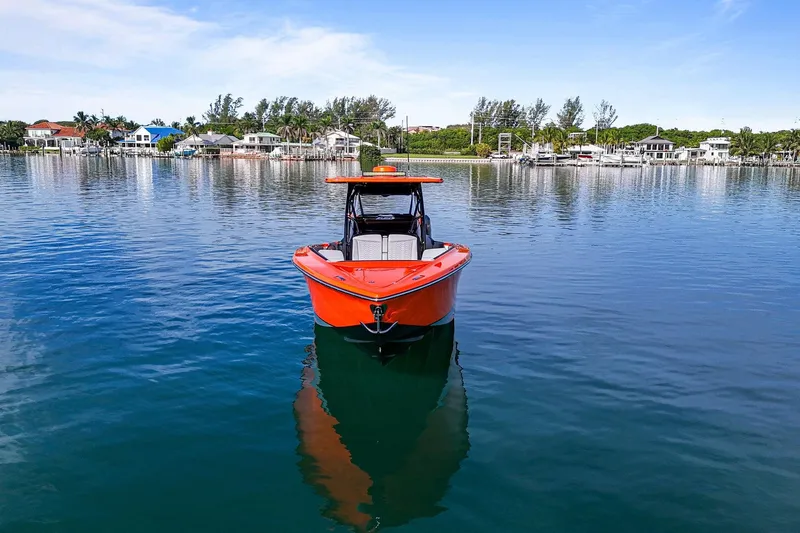 Slide: The Image of 2026 Nor-Tech 390 Sport Center Console boat on calm water, with scenic waterfront background. - 1