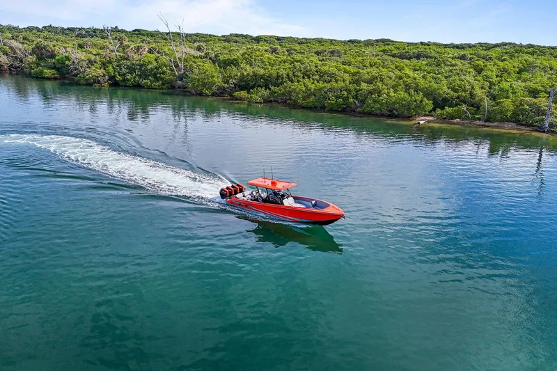 Slide: The Image of 2026 Nor-Tech 390 Sport Center Console cruising on a serene, tree-lined waterway. - 10