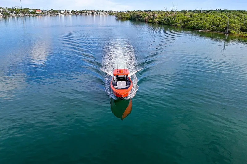 Slide: The Image of 2026 Nor-Tech 390 Sport Center Console cruising on a serene lake. - 11