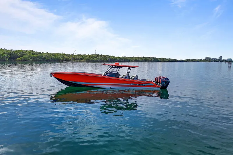 Slide: The Image of 2026 Nor-Tech 390 Sport Center Console boat on calm water, vibrant orange design. - 12