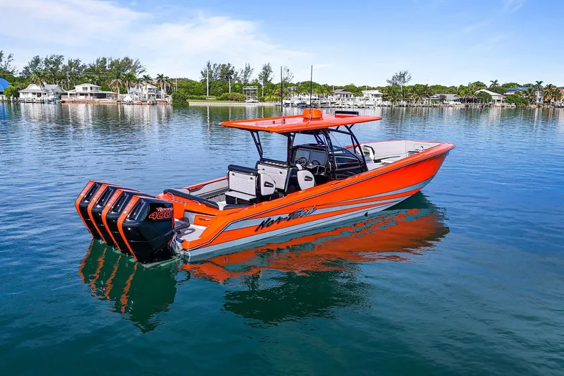 Slide: The Image of 2026 Nor-Tech 390 Sport Center Console boat on calm water, vibrant orange design. - 13
