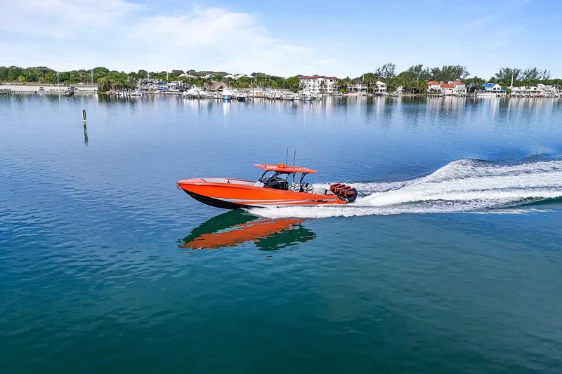 Slide: The Image of 2026 Nor-Tech 390 Sport Center Console cruising on calm waters, vibrant orange design. - 17