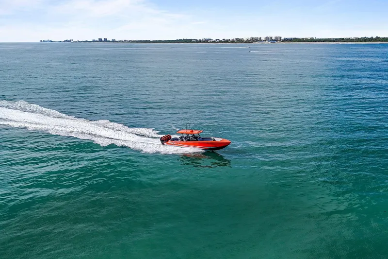 Slide: The Image of 2026 Nor-Tech 390 Sport Center Console cruising on open water, distant shoreline visible. - 19