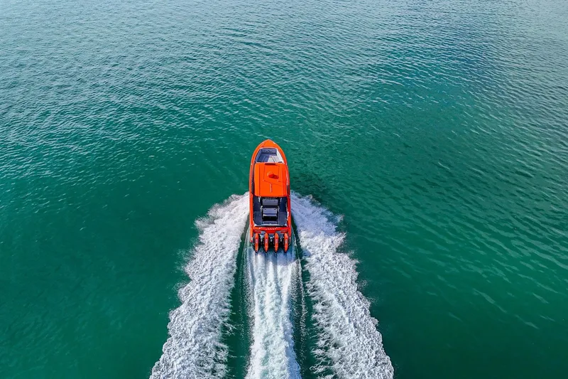 Slide: The Image of 2026 Nor-Tech 390 Sport Center Console speeding on open water, aerial view. - 20