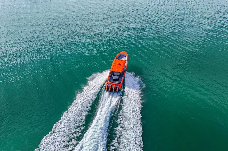 Slide: The Image of Aerial view of 2026 Nor-Tech 390 Sport Center Console speeding on turquoise water. - 21