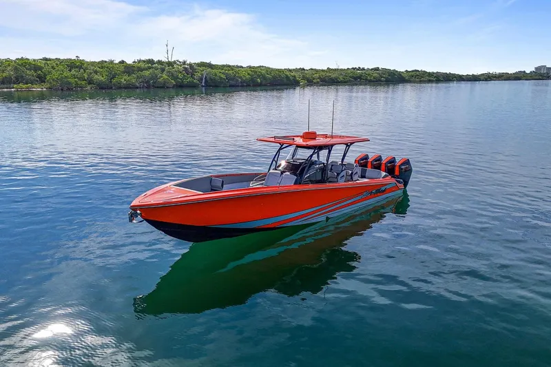 Slide: The Image of 2026 Nor-Tech 390 Sport Center Console boat on calm water, vibrant orange design. - 23