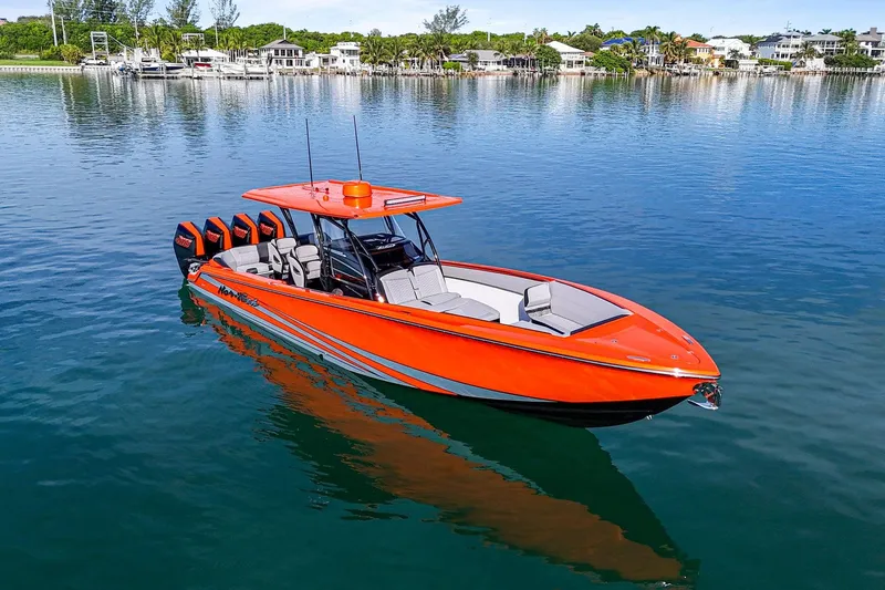 Slide: The Image of 2026 Nor-Tech 390 Sport Center Console boat on calm water, vibrant orange design. - 25
