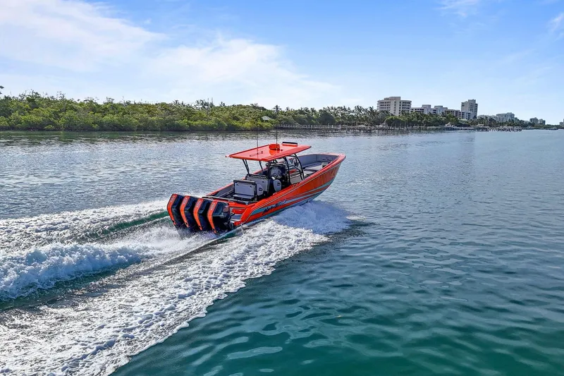 Slide: The Image of 2026 Nor-Tech 390 Sport Center Console cruising on a sunny day near a coastal city. - 28