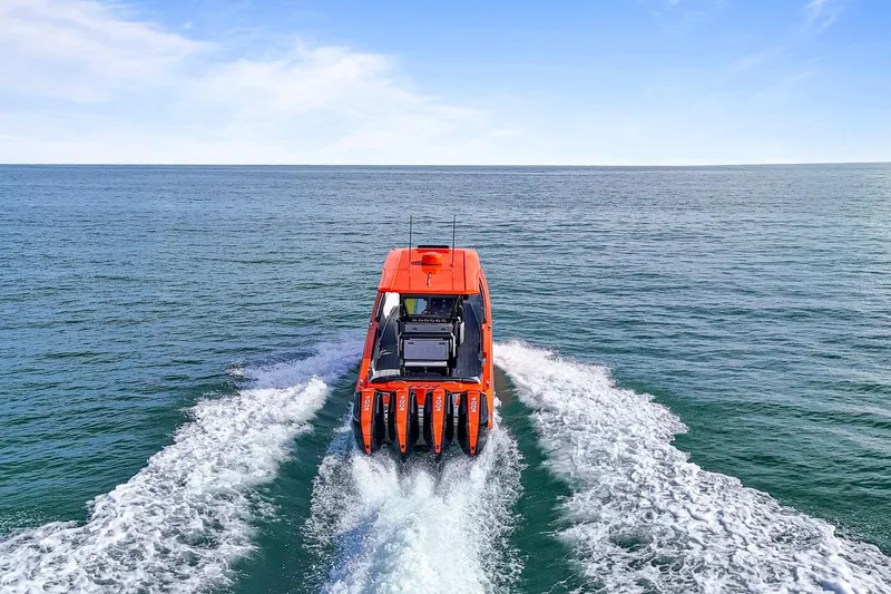 Slide: The Image of Nor-Tech 390 Sport Center Console 2026 cruising on open water, rear view. - 30