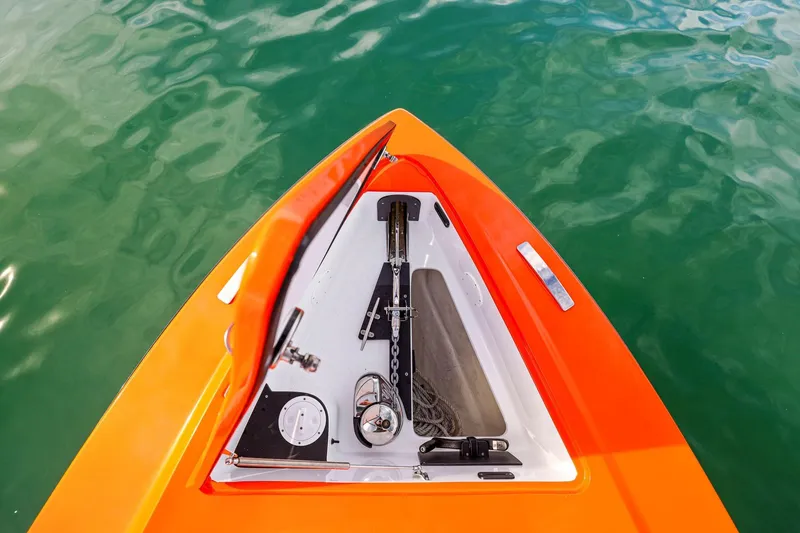 Slide: The Image of Bow of 2026 Nor-Tech 390 Sport Center Console in vibrant orange, anchored in clear water. - 54
