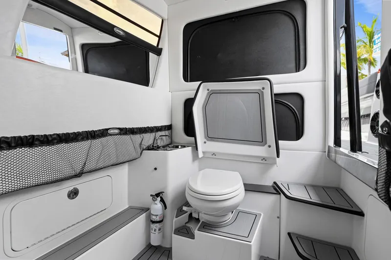 Slide: The Image of Interior of 2026 Nor-Tech 390 Sport Center Console boat, featuring a compact bathroom. - 57
