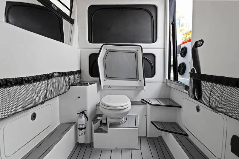 Slide: The Image of 2026 Nor-Tech 390 Sport Center Console boat interior with toilet and storage compartments. - 59