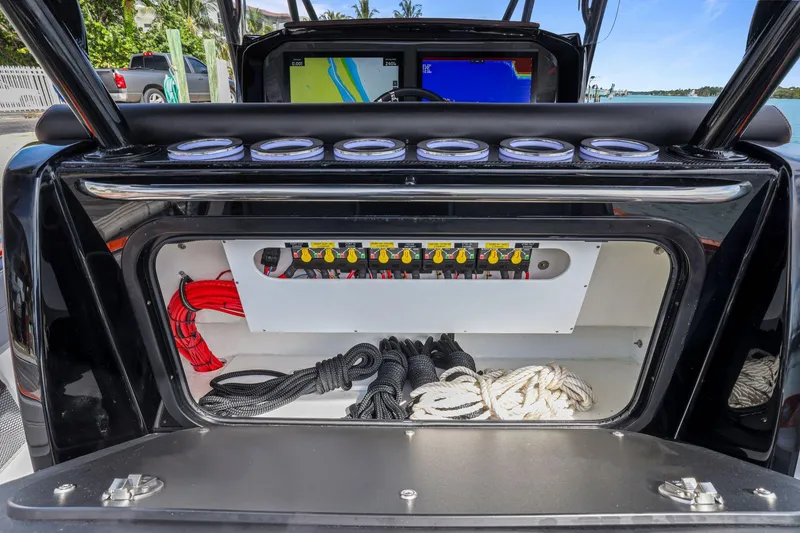 Slide: The Image of 2026 Nor-Tech 390 Sport Center Console storage compartment with ropes and control panel. - 63