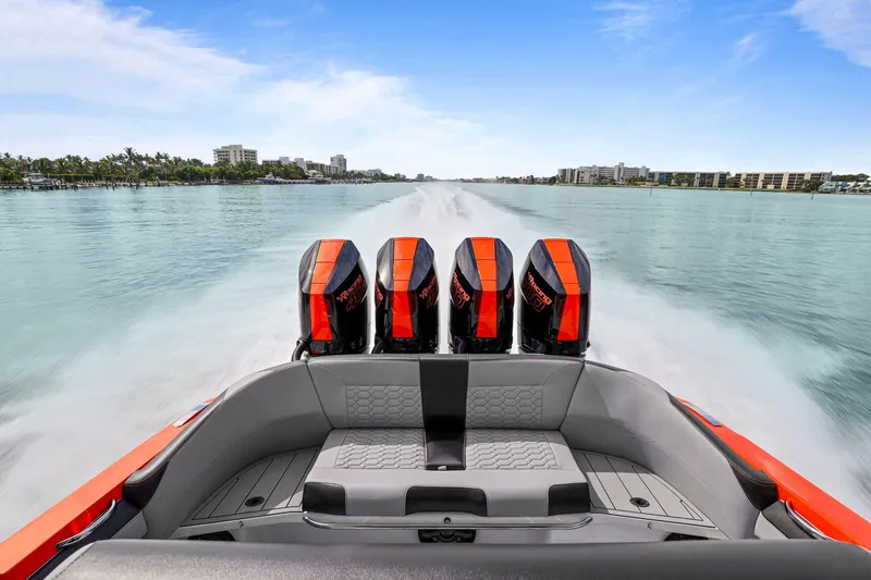 Slide: The Image of 2026 Nor-Tech 390 Sport Center Console with quad engines cruising on a clear waterway. - 69