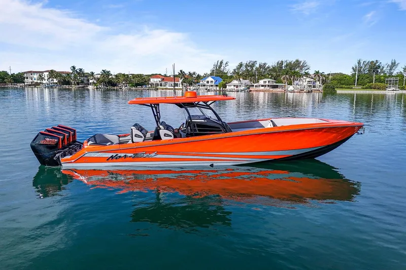 Slide: The Image of 2026 Nor-Tech 390 Sport Center Console boat in vibrant orange on calm water. - 7