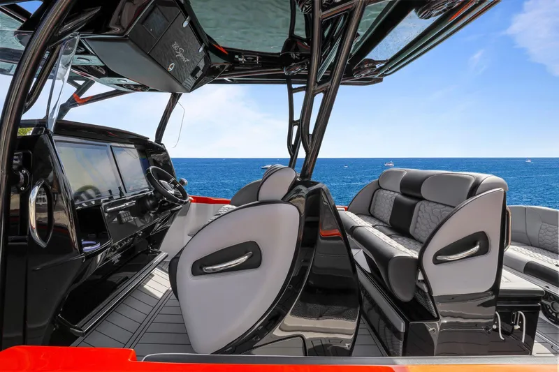 Slide: The Image of 2026 Nor-Tech 390 Sport Center Console boat interior with ocean view, featuring sleek seating and controls. - 74