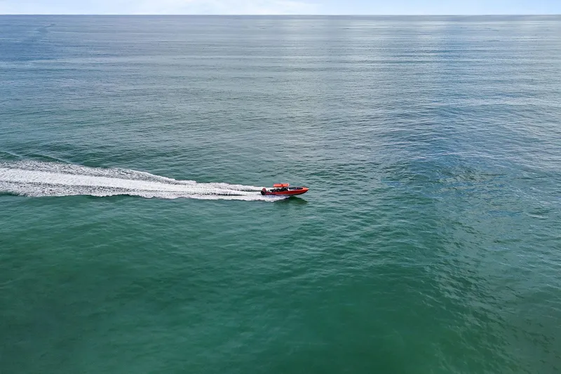 Slide: The Image of Aerial view of 2026 Nor-Tech 390 Sport Center Console speeding on open ocean. - 8