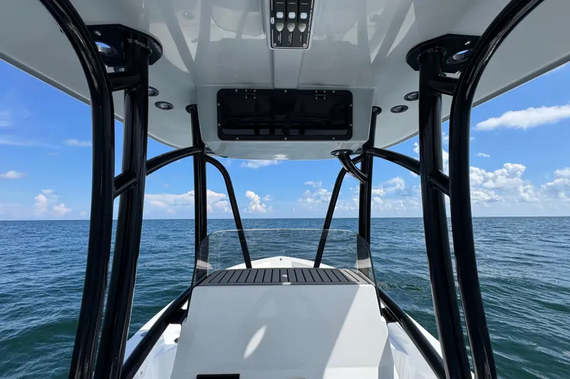 Slide: The Image of 2026 BlackJack 256 Bay boat interior with seating and console, parked outdoors. - 20