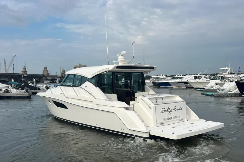 Slide: The Image of 2023 Tiara Yachts C44 Coupe in marina, rear view, overcast sky. - 20