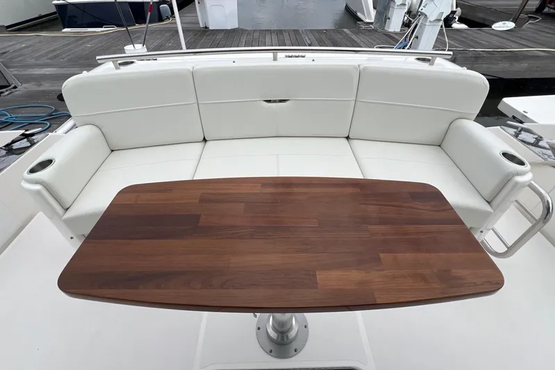 Slide: The Image of 2023 Tiara Yachts C44 Coupe interior with white seating and wooden table. - 22
