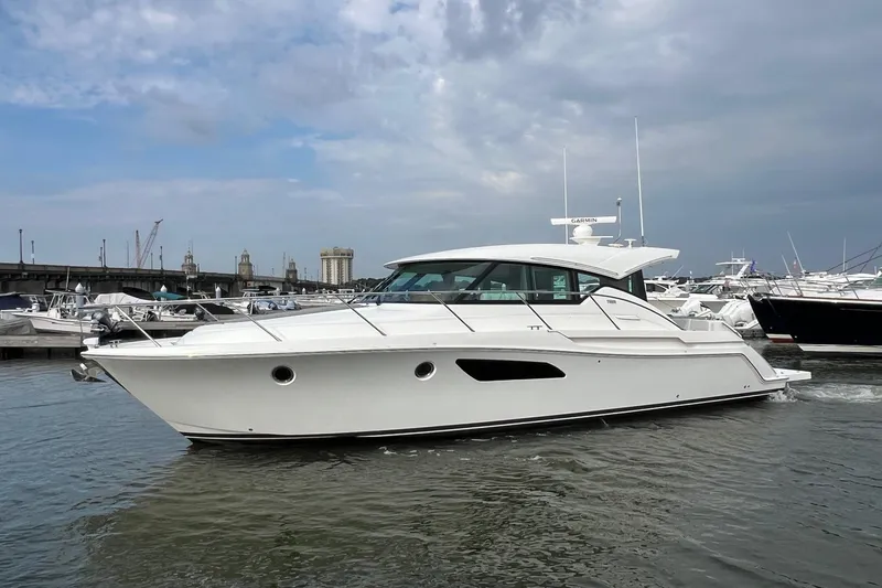 Slide: The Image of 2023 Tiara Yachts C44 Coupe in marina, sleek design, overcast sky. - 3