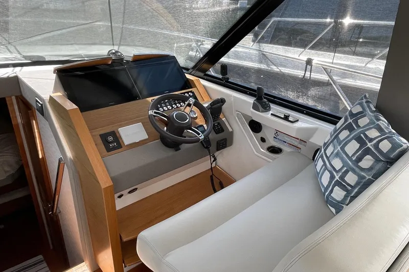 Slide: The Image of 2023 Tiara Yachts C44 Coupe helm with modern controls and cushioned seating. - 32