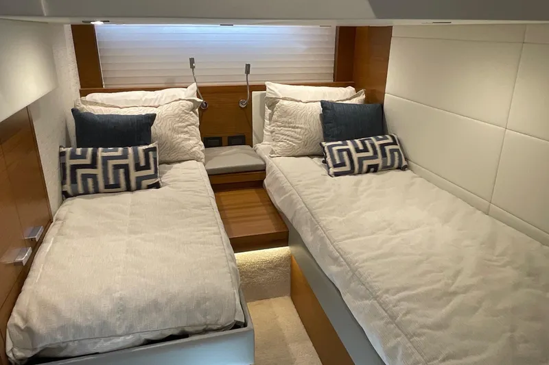 Slide: The Image of 2023 Tiara Yachts C44 Coupe interior with twin beds and decorative pillows. - 38