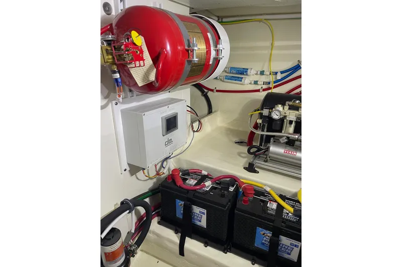 Slide: The Image of Engine room of 2023 Tiara Yachts C44 Coupe with fire extinguisher and battery setup. - 53