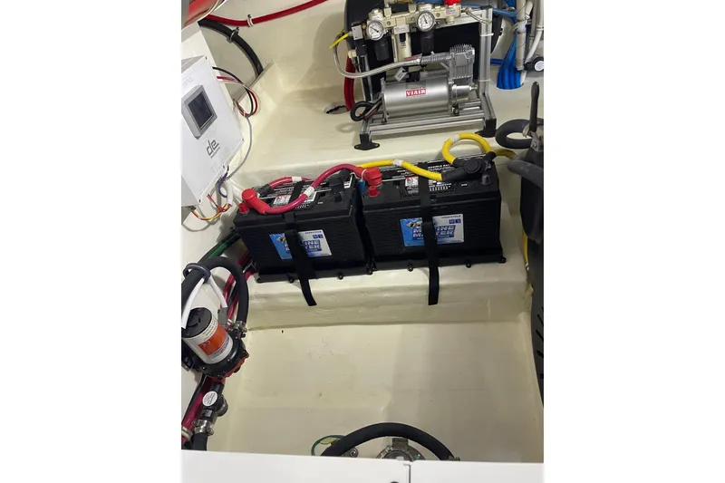 Slide: The Image of Engine compartment of 2023 Tiara Yachts C44 Coupe with batteries and wiring. - 54