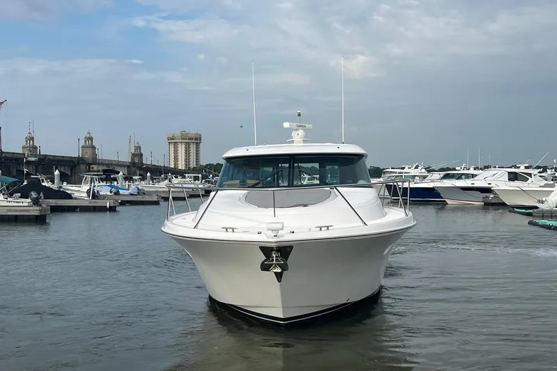 Slide: The Image of 2023 Tiara Yachts C44 Coupe docked in a marina, surrounded by other boats. - 7
