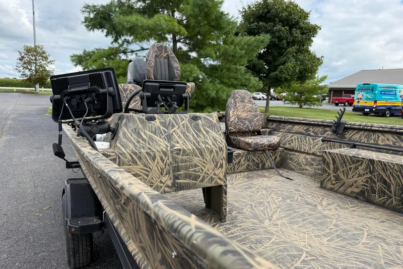 Slide: The Image of 2023 Lowe Roughneck 2070SC boat with camouflage design, featuring seating and control panel. - 12