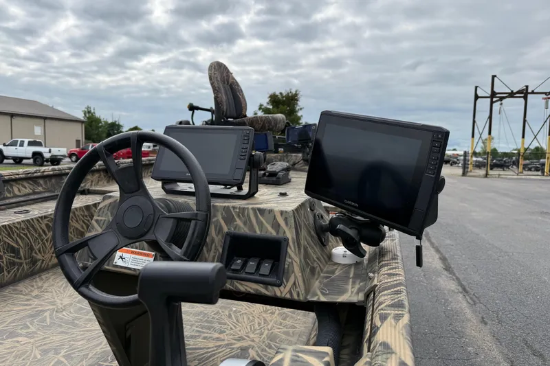 Slide: The Image of 2023 Lowe Roughneck 2070SC boat dashboard with steering wheel and navigation screens. - 13