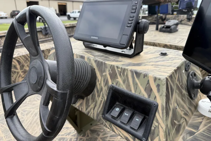 Slide: The Image of Steering console of 2023 Lowe Roughneck 2070SC with camouflage design and Garmin display. - 14