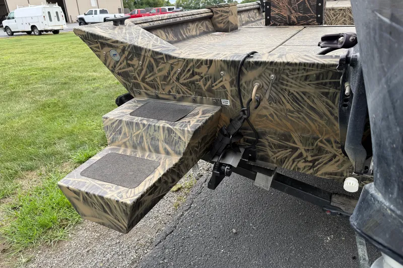 Slide: The Image of 2023 Lowe Roughneck 2070SC boat with camouflage design and rear steps. - 18