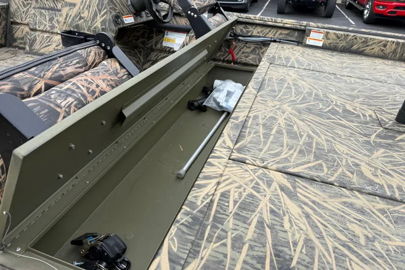 Slide: The Image of 2023 Lowe Roughneck 2070SC boat interior with camouflage seating and storage compartments. - 21