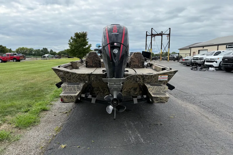 Slide: The Image of 2023 Lowe Roughneck 2070SC boat with camo design, parked outdoors on a cloudy day. - 4