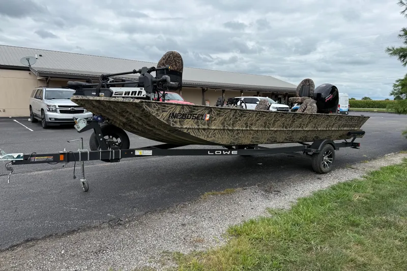 Slide: The Image of 2023 Lowe Roughneck 2070SC boat on trailer, parked outdoors under cloudy sky. - 7