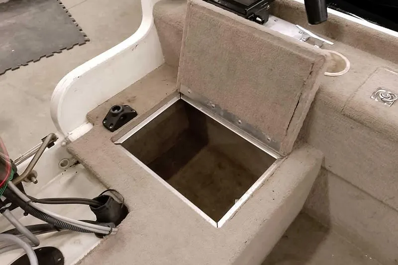 Slide: The Image of Open storage compartment on a 2005 Monark Signature 1601 boat interior. - 18