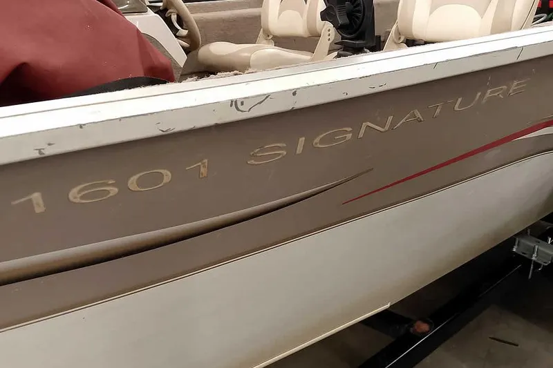 Slide: The Image of 2005 Monark Signature 1601 boat with beige interior and visible branding. - 3