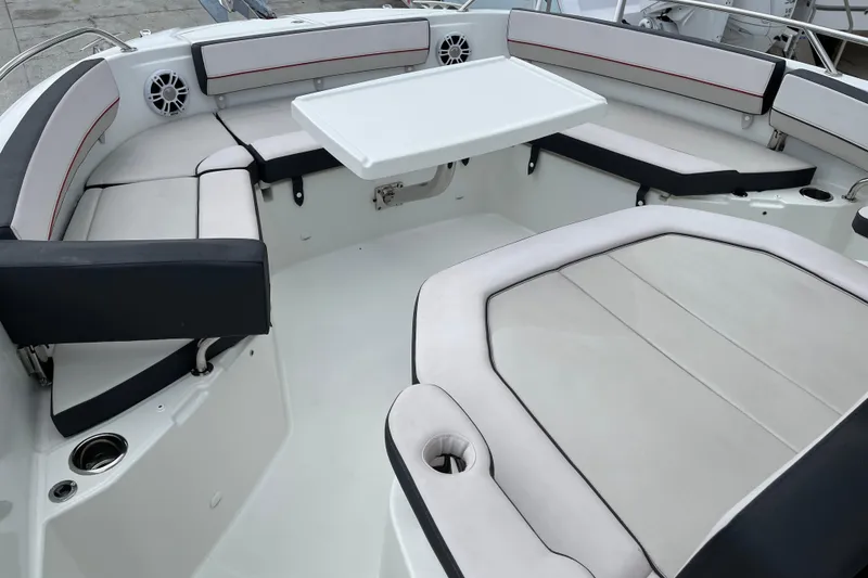 Slide: The Image of 2024 Jeanneau Leader 10.5 CC boat interior with seating, table, and kitchenette. - 4