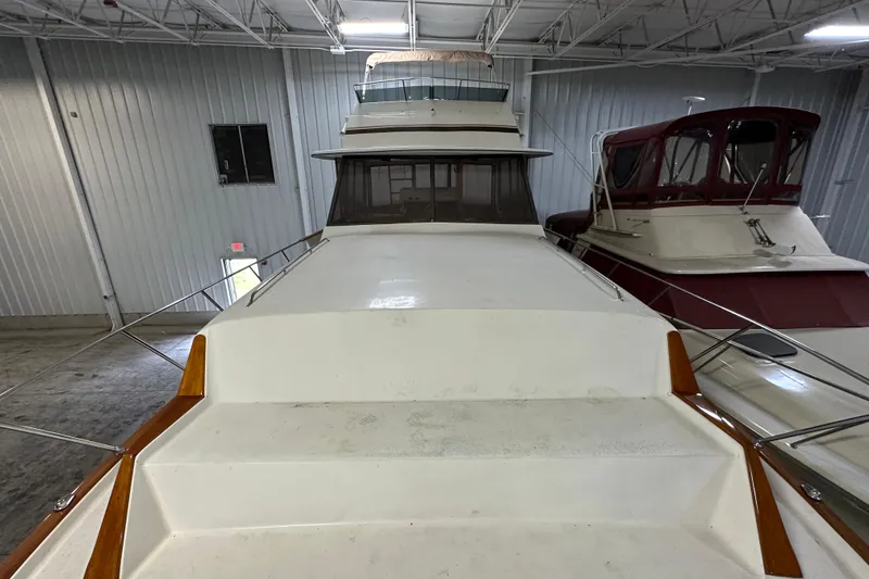 Slide: The Image of 1982 Egg Harbor 42 Flybridge Motoryacht in indoor storage, showcasing spacious deck and sleek design. - 12