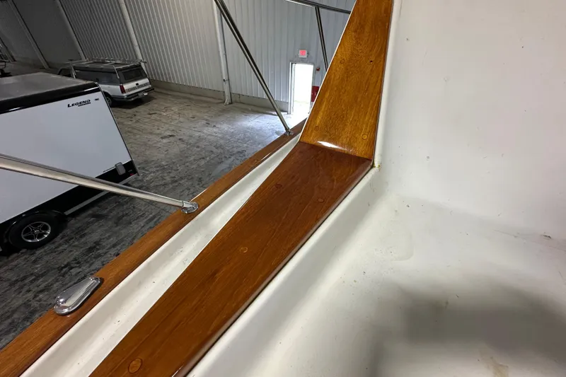 Slide: The Image of 1982 Egg Harbor 42 Flybridge Motoryacht with polished wood and metal railings in a warehouse. - 13