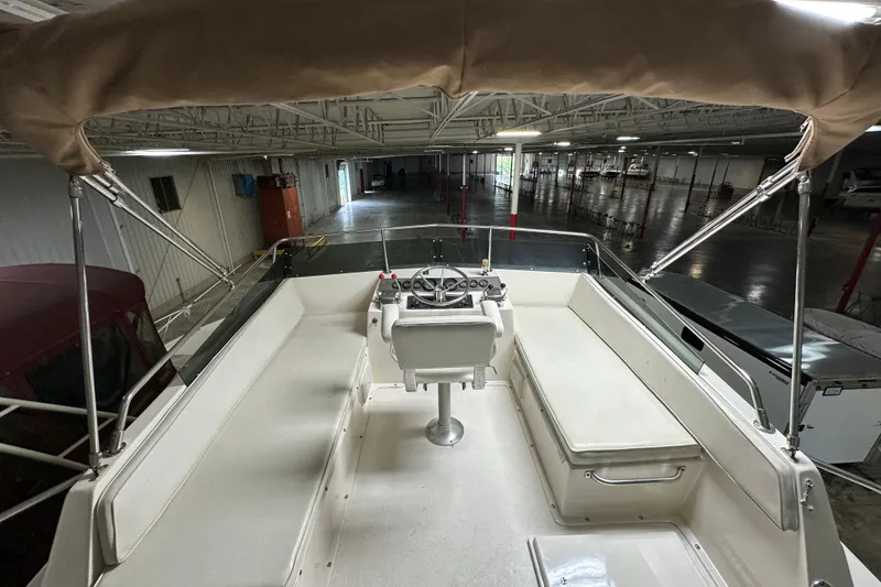 Slide: The Image of 1982 Egg Harbor 42 Flybridge Motoryacht interior with helm, seating, and canopy in storage facility. - 21