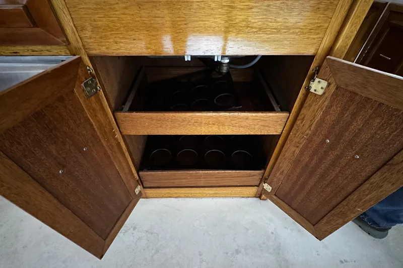 Slide: The Image of Open wooden cabinet with shelves inside Egg Harbor 42 Flybridge Motoryacht, 1982 model. - 33