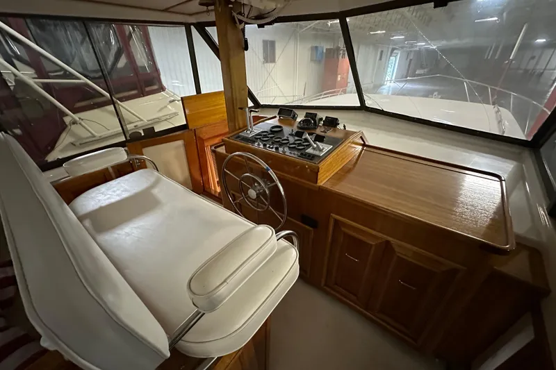 Slide: The Image of 1982 Egg Harbor 42 Flybridge Motoryacht helm with wooden dashboard and steering wheel. - 35