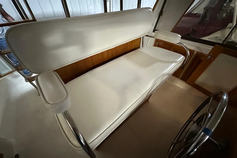 Slide: The Image of 1982 Egg Harbor 42 Flybridge Motoryacht interior with white cushioned seating and steering wheel. - 36