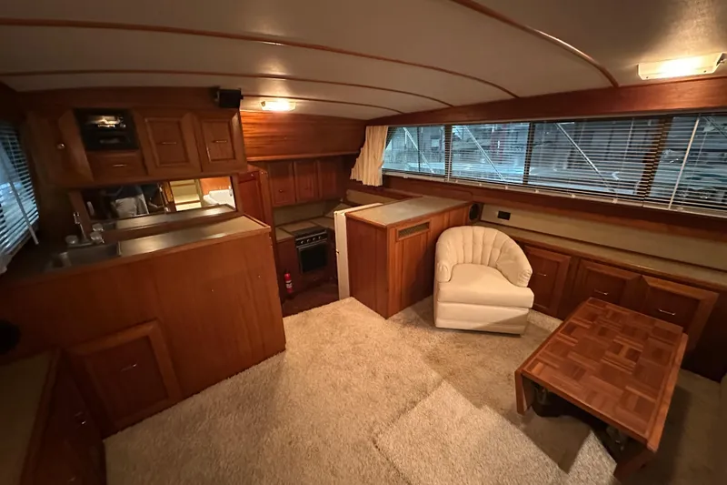 Slide: The Image of Interior of 1982 Egg Harbor 42 Flybridge Motoryacht with wood cabinetry and cozy seating area. - 50