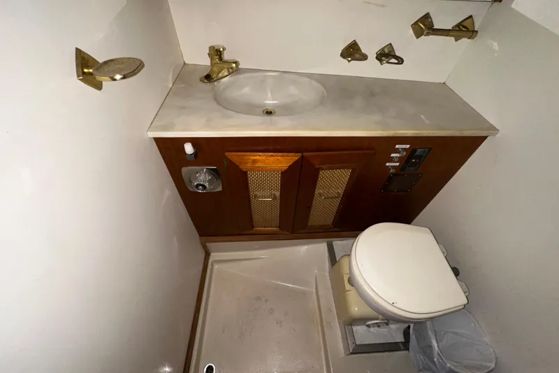 Slide: The Image of 1982 Egg Harbor 42 Flybridge Motoryacht bathroom with sink, toilet, and wooden cabinetry. - 69