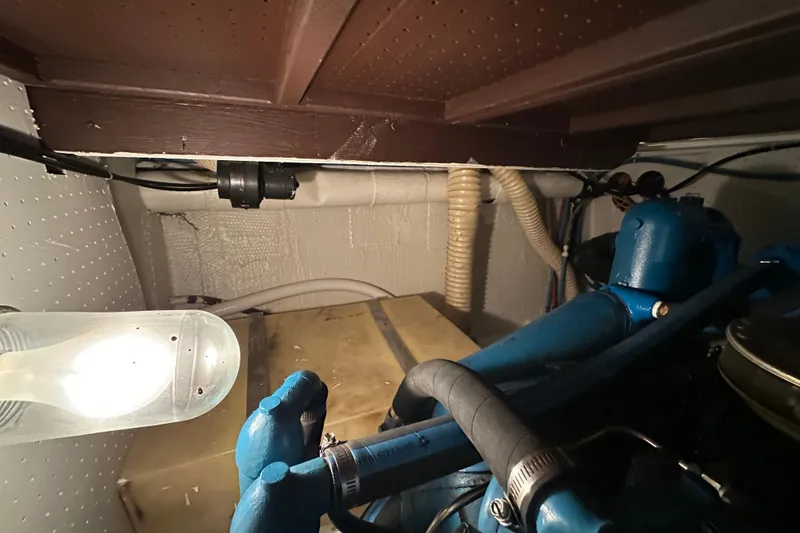 Slide: The Image of Engine room of 1982 Egg Harbor 42 Flybridge Motoryacht with visible blue engine components. - 79